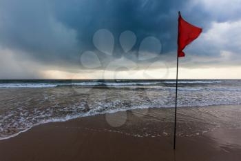 Danger concept background - severe storm warning flags on beach. Baga, Goa, India