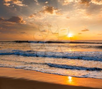 Sunrise with rising sun on morning beach