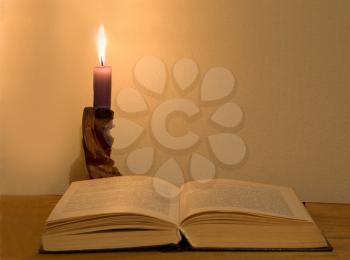 Old magic book and glowing candle.Magic education.
