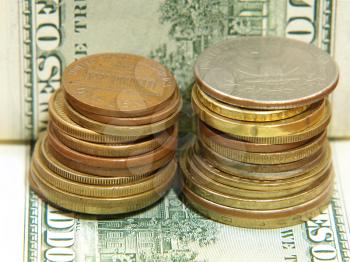 Coins stacks on a dollar banknote taken closeup.