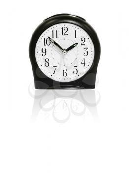 Black alarm clock with reflection on white background.