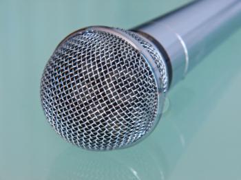 Metallic microphone taken closeup on a transparent background.