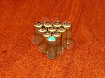 Gas cartridges in a triangle pyramide row on a polished table surface.