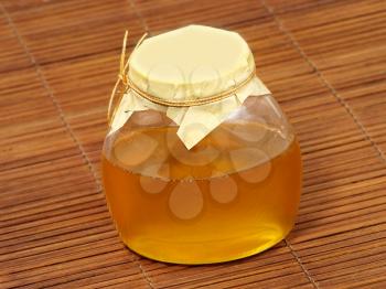 Honey jar on a wooden surface.