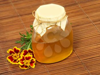 Honey jar and yellow flower.