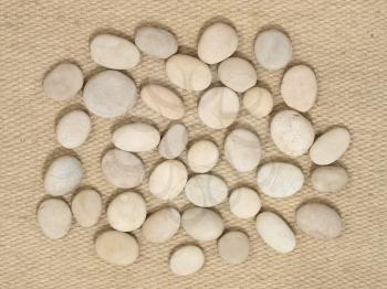 Small stones on a camal wool fabric  suitable as background.