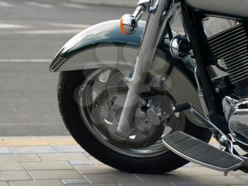 Motorcycle wheel on a background of road asphalt.
