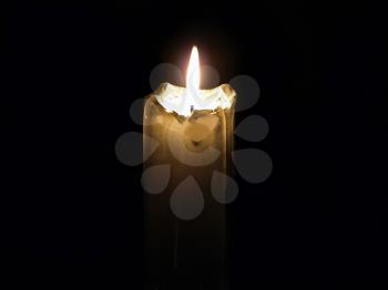Glowing mourning candle in a darkness.