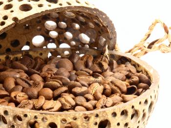 Coffee beans in a pot of coconut on a white background.