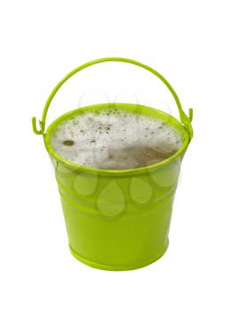 Green bucket with foaming liquid isolated on white background.