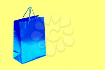 Empty blue shopping bag isolated on yellow background.