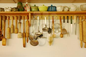 Kitchen ware hanging on the white wall.