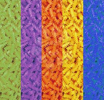 Multicolored collage of dry pasta spirals suitable as food background.