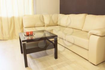 Modern comfortable white corner leather sofa and coffee table.
