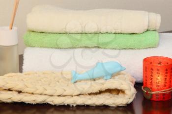 Towel stack, bast and soap in the form of a dolphin taken closeup.