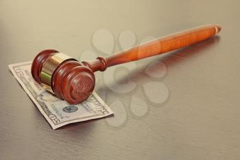 Judge gavel with fifty dollars banknote on wooden table taken closeup.