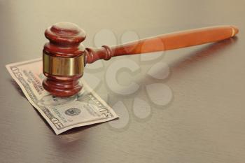 Judge gavel and fifty dollars banknote on wooden table.