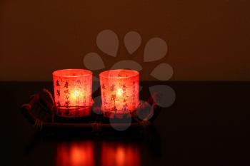 Two red chinese decorative candles on table in darkness.