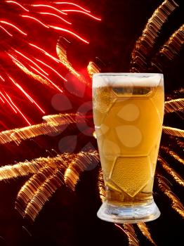 Froth beer glass on multicolored fireworks background.