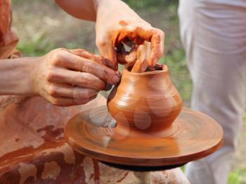 Pottery manufacturing process.Potter makes on pottery wheel clay pot.