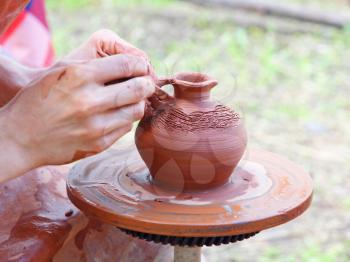 Potter makes on pottery wheel clay pot.Taken closeup.