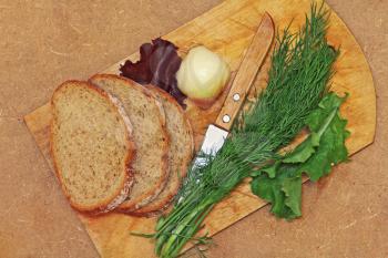 Fresh dill,bread and knife on wooden cutting board taken closeup.Top view.