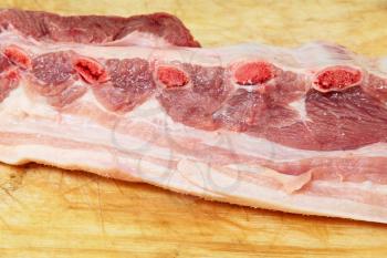 Appetizing raw pork ribs on wooden cutting board taken closeup.