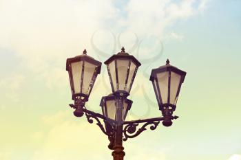 Vintage street light against blue sky.Toned image.