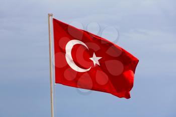 Turkish flag taken closeup against of the blue sky.