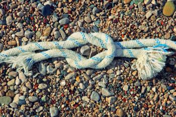 Straight sea knot on small vivid pebble background.Toned image.