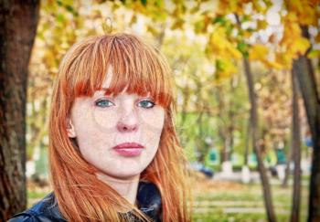 Pretty red hair girl with freckles looks at camera. Digitally altered image.