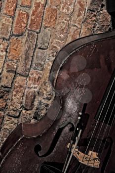 Contrabass near old brick wall.Toned image.