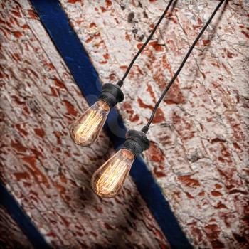 Incandescence lamp on red and white brick grunge ceiling.