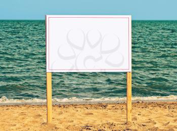 Blank billboard on sandy beach against of sea surf.Just add your text.