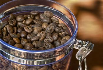 Coffee beans in glass container taken closeup.