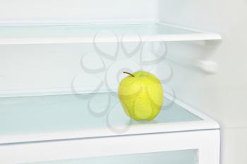 Lifestyle concept.Yellow apple in domestic refrigerator taken closeup.Toned image.