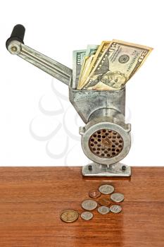 Dollar banknotes in meat grinder and coins on wooden table.Toned image.