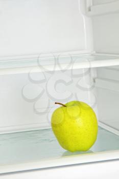 Lifestyle concept.Yellow apple in domestic refrigerator taken closeup.