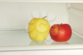 Healthy lifestyle.Red and yellow apple in domestic refrigerator taken closeup. Toned image.