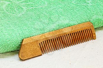 Wooden Hair Comb and Green Towel on White Cloth.Taken Closeup.