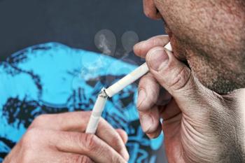 Men lighting a cigarette of his friend taken closeup.Toned image.