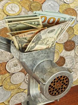 Money and business concept.Dollar banknotes in meat grinder on lot of different coins background.