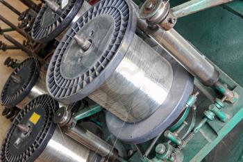 Steel wire spools of Braiding machine taken closeup.Flexible metal hose production line.