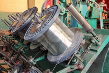 Flexible metal hose production line.Steel wire spools of Braiding machine closeup.