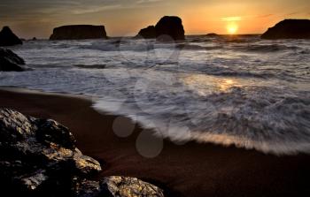 Sunset Bandon Oregon rock formation and ocean waves