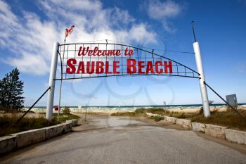 Sauble Beach Sign over roadway entrance red letters