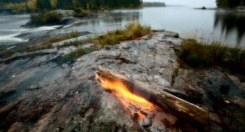 Log on fire Manitoba lake wilderness
