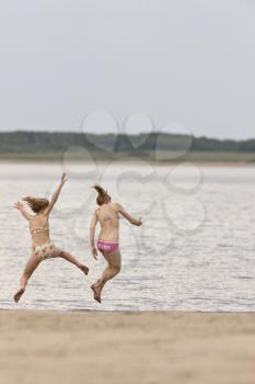 Girls playing along lake shore