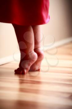 Baby Feet Stretching on Wooden Floor