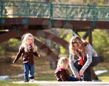 Mother with two daughters at park in autumn